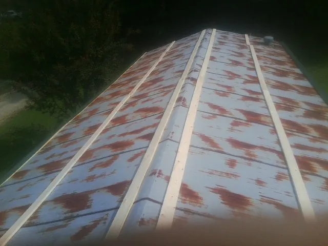 Rusted metal roof panels with new wood purlins before replacement — Storm Damage Roof Repair in Millwood by Roofing Brothers